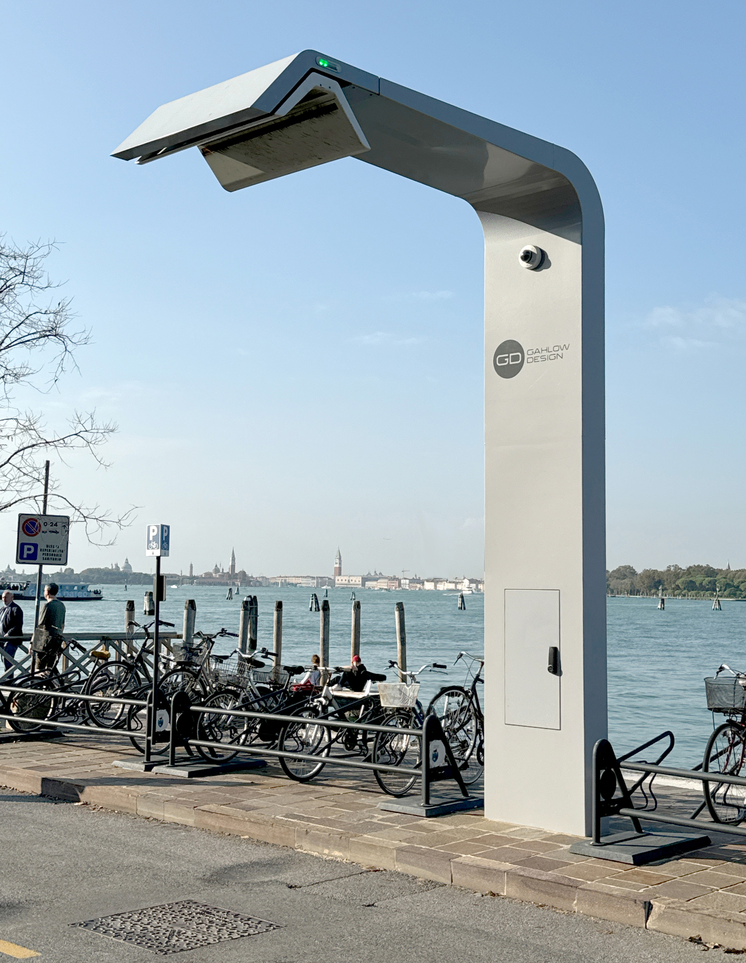 E-Bus-Lademast auf dem Lido in Venedig. Lichtgrauer Mast mit Schunk-Ladehaube vor dem Hintergrund der Silhouette von Venedig